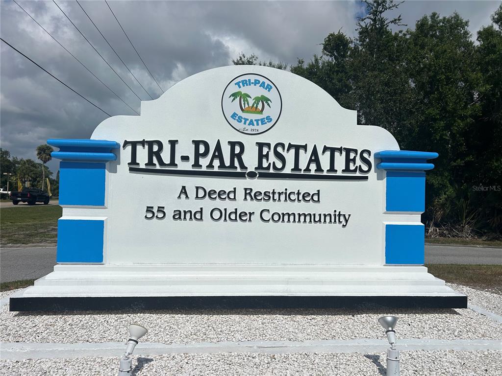A white monument sign for Tri-Par Estates stands outdoors against a cloudy sky — 5025 BRAE BURN AVENUE, SARASOTA, FL