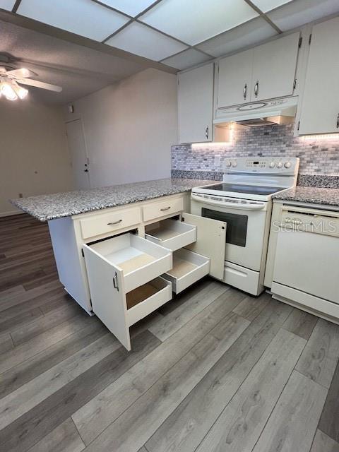 A kitchen features white cabinets, granite countertops, stainless steel appliances, and light wood-look flooring — 21260 BRINSON AVENUE UNIT 211, PORT CHARLOTTE, FL