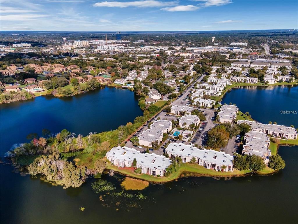 An aerial view shows a multi-building apartment complex situated on a peninsula in a lake — 512 ORANGE DRIVE UNIT 30, ALTAMONTE SPRINGS, FL