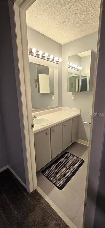 A bathroom features a vanity with a white countertop, gray cabinets, and a wall mirror — 512 ORANGE DRIVE UNIT 30, ALTAMONTE SPRINGS, FL