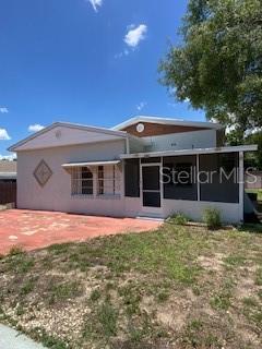 A single-story house with a screened-in porch, a red paved patio, and a grassy yard — 312 MILAKEE AVENUE, SEBRING, FL