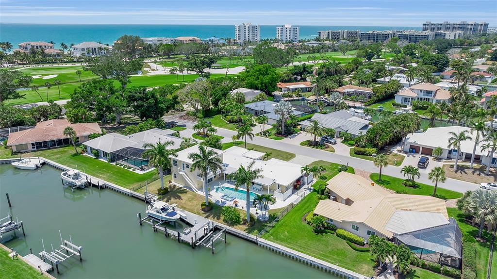 An aerial view of waterfront houses with private docks, swimming pools, and a nearby golf course — 524 HORNBLOWER LANE, LONGBOAT KEY, FL
