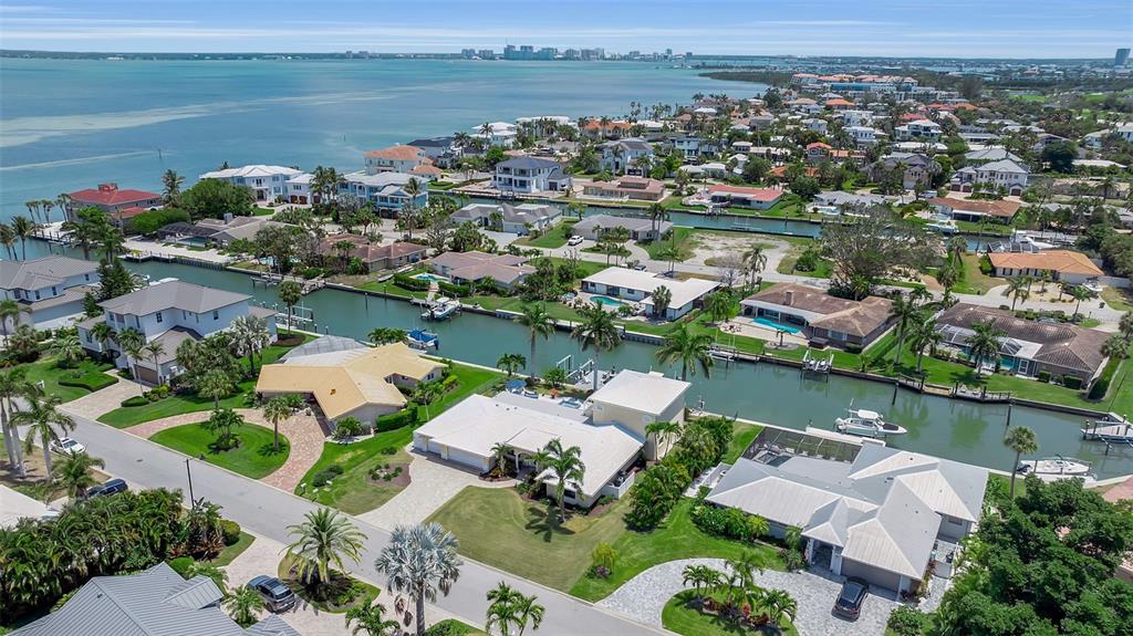 An aerial view shows waterfront homes with private docks along a canal near the bay — 524 HORNBLOWER LANE, LONGBOAT KEY, FL
