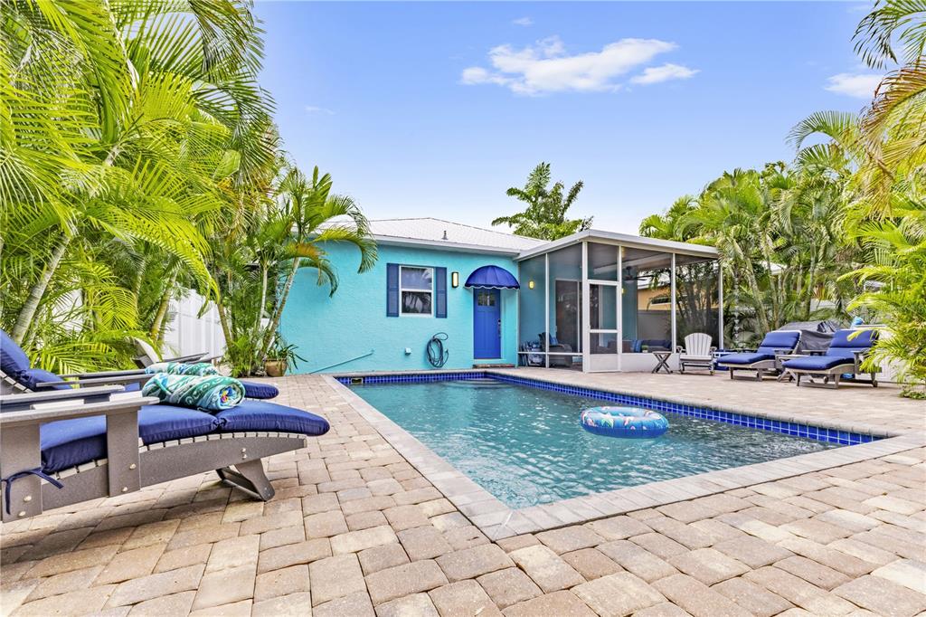 A turquoise house with a blue door and a swimming pool in the backyard — 2047 ROSELAWN STREET, SARASOTA, FL