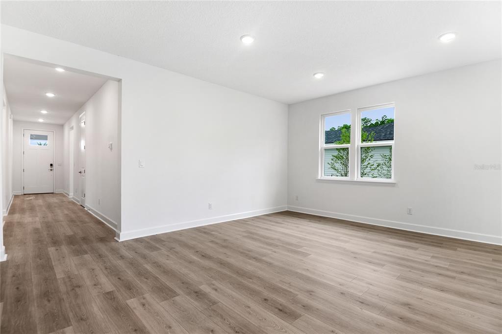 An empty room with light wood-look flooring, white walls, recessed lighting, and a window — 37 PONCE PRESERVE DRIVE, PALM COAST, FL