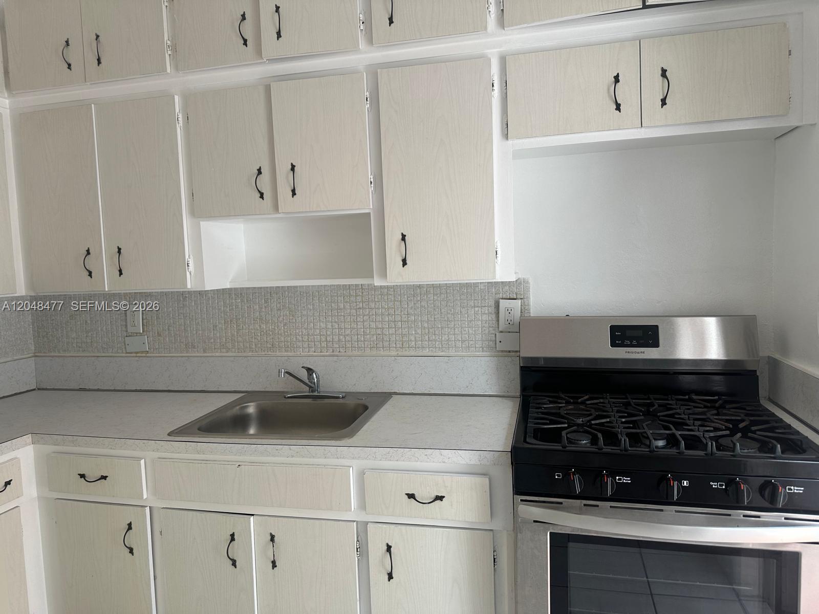 A kitchen features light wood-grain cabinets, a stainless steel sink, and a black gas range — 7860 Harding Ave # 4B, Miami Beach FL 33141, MIAMI BEACH, FL