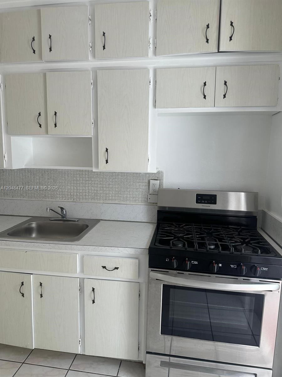A kitchen features light wood-grain cabinets, a stainless steel gas range, and a metal sink — 7860 Harding Ave # 4B, Miami Beach FL 33141, MIAMI BEACH, FL