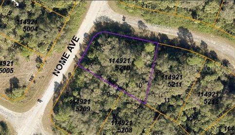 This aerial map shows a vacant, wooded residential lot outlined in purple along a paved road — NOME AVENUE, NORTH PORT, FL