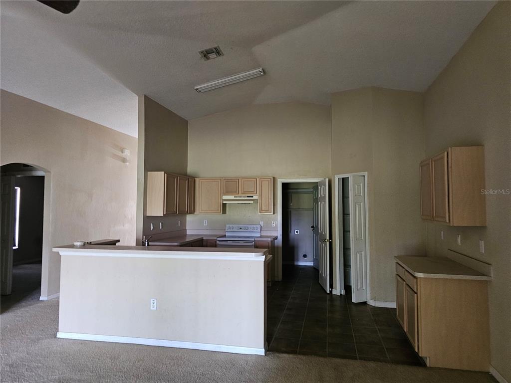 A kitchen with light wood cabinets, a breakfast bar, and tile flooring — 7 HADDOCK WAY, KISSIMMEE, FL