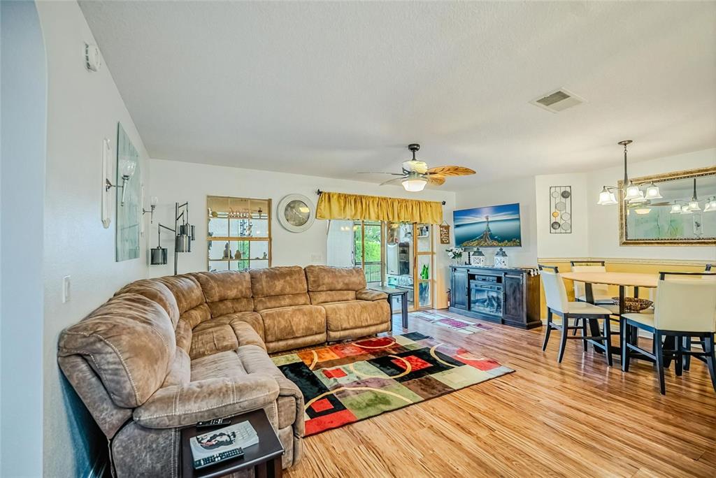 A living room features a brown sectional sofa, a colorful area rug, and a dining area — 8327 SW 79TH CIRCLE, OCALA, FL