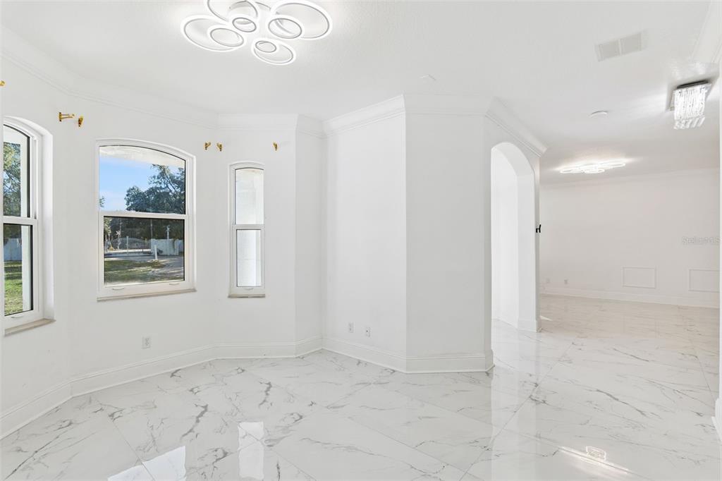 A bright room features white walls, marble-patterned tile flooring, and modern circular ceiling light fixtures — 20 REWIS STREET, OCOEE, FL