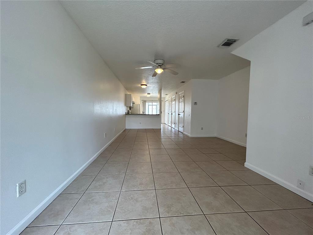 An open-concept living and dining area features light-colored tile flooring and a ceiling fan — 3076 SHINGLE CREEK COURT, KISSIMMEE, FL