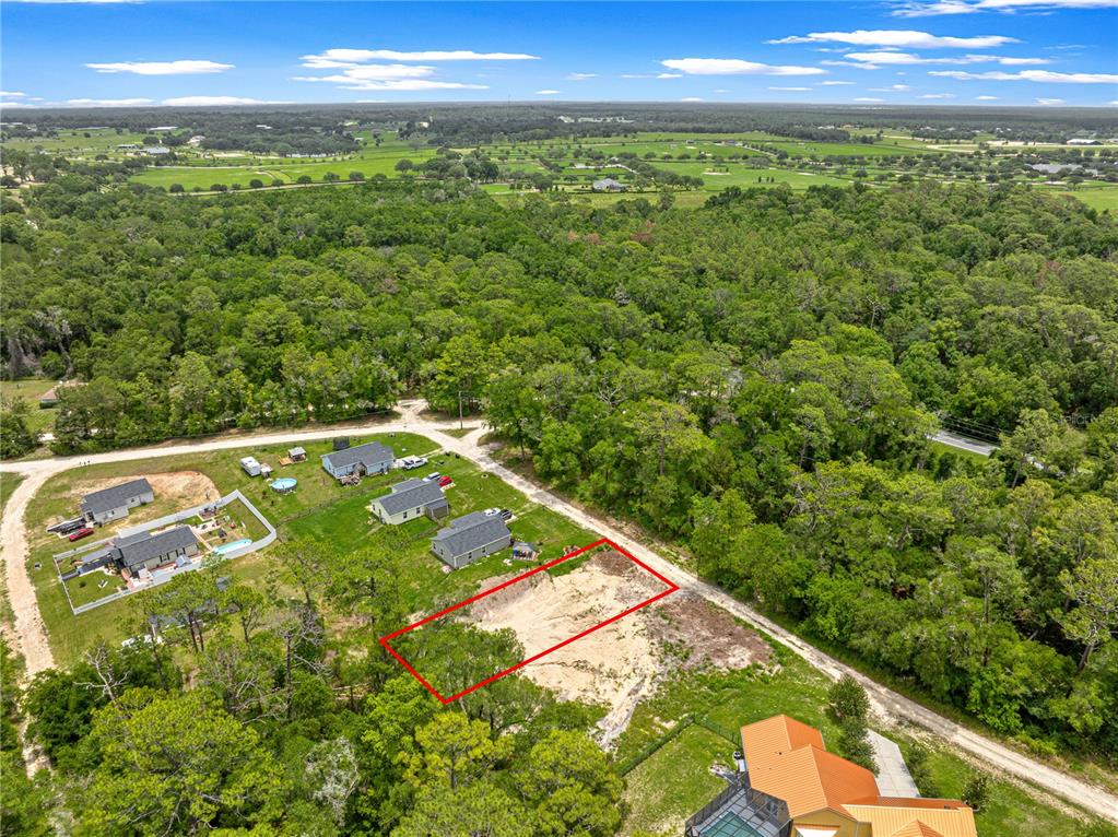 An aerial view shows a cleared, rectangular lot outlined in red next to several houses — SW 41ST STREET ROAD, OCALA, FL