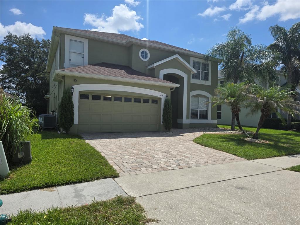 A two-story house with a green exterior, a paved driveway, and a two-car garage — 1349 WILLOW BRANCH DRIVE, ORLANDO, FL
