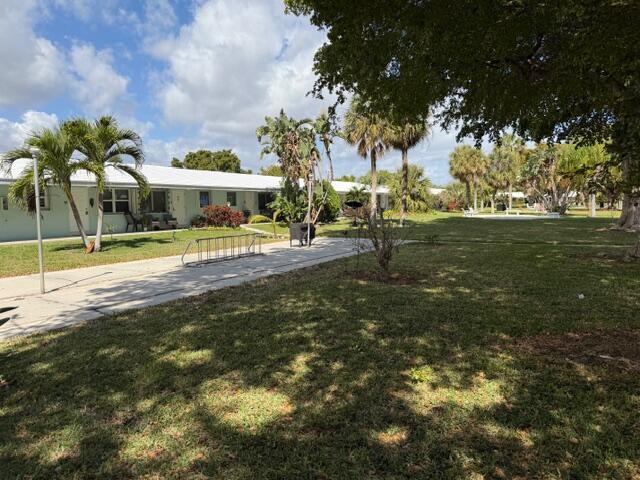 A single-story apartment building with a white roof sits beside a large, grassy lawn — 3801 NE 22nd Terrace # 12, Lighthouse Point FL 33064, LIGHTHOUSE POINT, FL