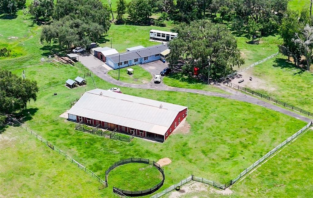 An aerial view shows a rural property with a large barn, house, and fenced pastures — 88 CULBREATH ROAD, BROOKSVILLE, FL