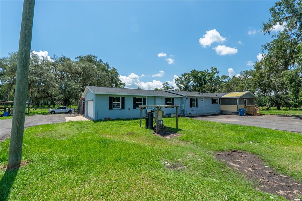 A blue single-story house with a garage and a screened porch sits on a lawn — 88 CULBREATH ROAD, BROOKSVILLE, FL