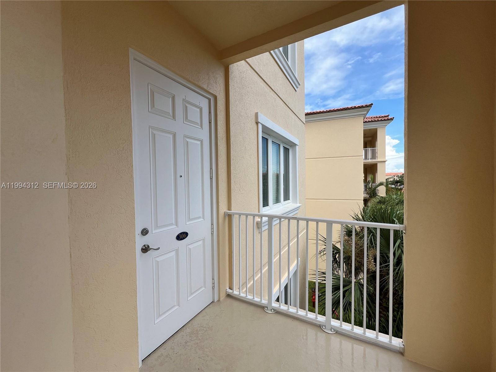A white door with a number plate opens onto a balcony with a metal railing — 5 E Harbour Isle # 306, Fort Pierce FL 34949, FORT PIERCE, FL