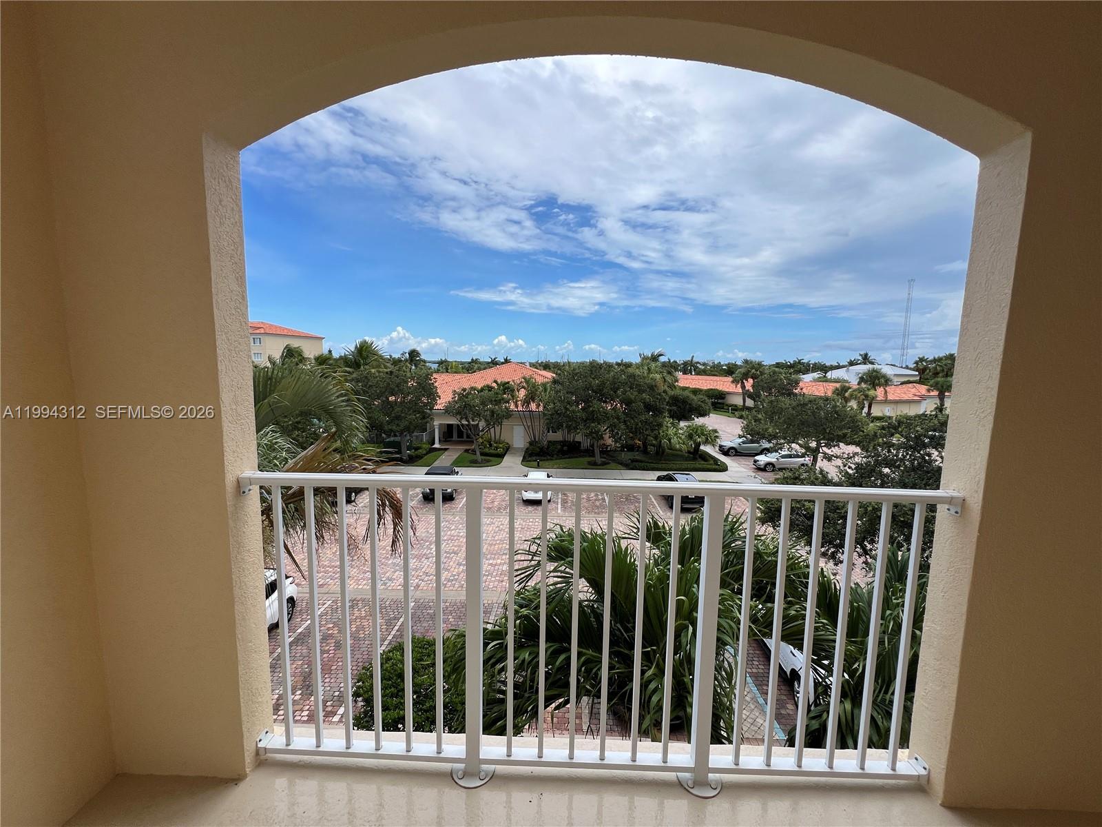A view of a parking lot and surrounding buildings from a covered balcony — 5 E Harbour Isle # 306, Fort Pierce FL 34949, FORT PIERCE, FL
