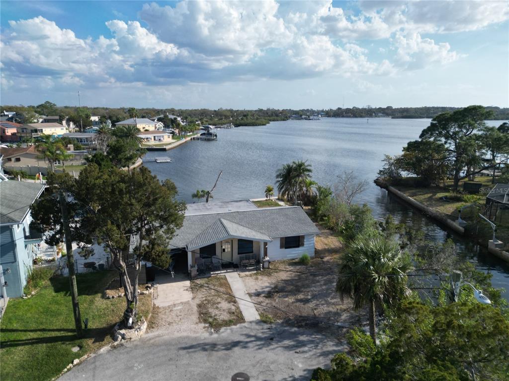 An aerial view of a waterfront house with a yard and a canal — 8402 DAMEN LANE, PORT RICHEY, FL