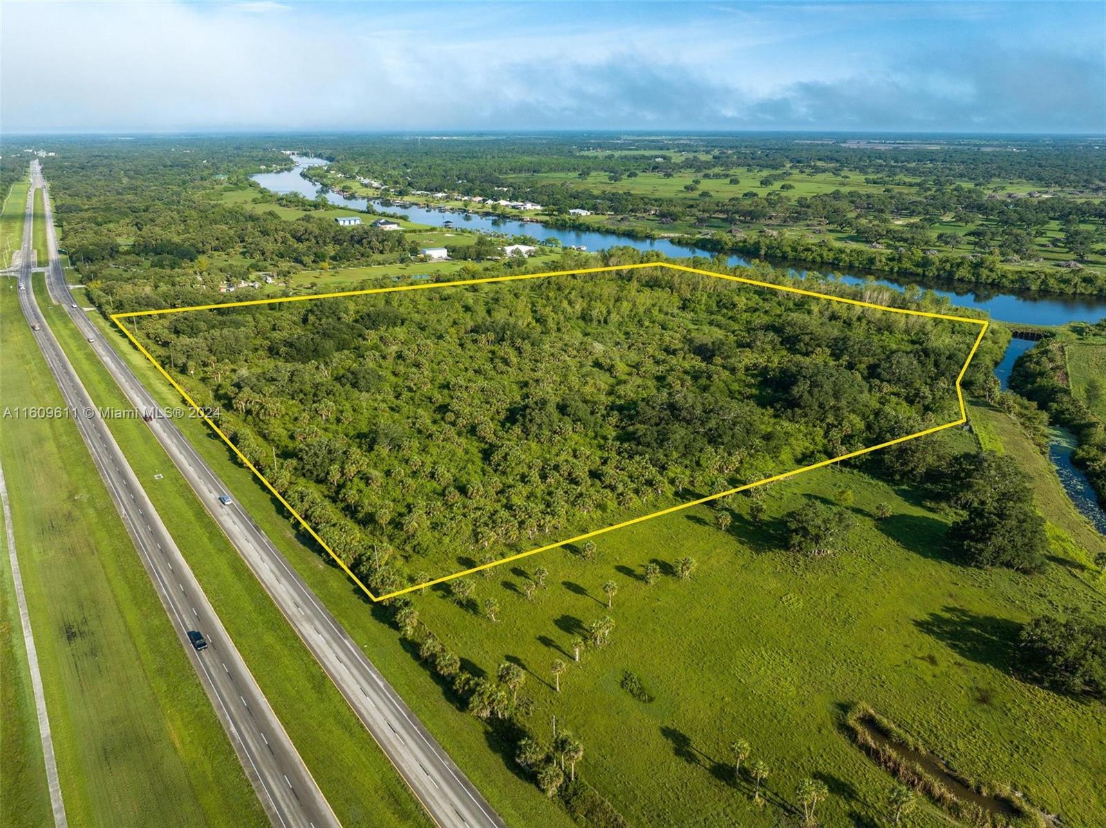 An aerial view shows a large, undeveloped rectangular plot of land bordering a highway — 1984 E State Road 80, La Belle FL 33935, LA BELLE, FL