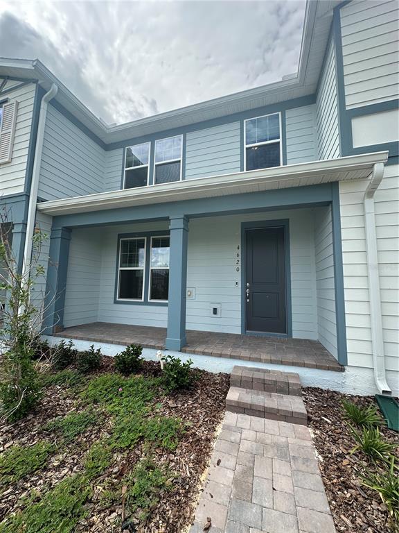 The exterior of a two-story house features light blue siding, a covered porch, and a walkway — 4620 ORCHARD VIEW ALLEY, CLERMONT, FL
