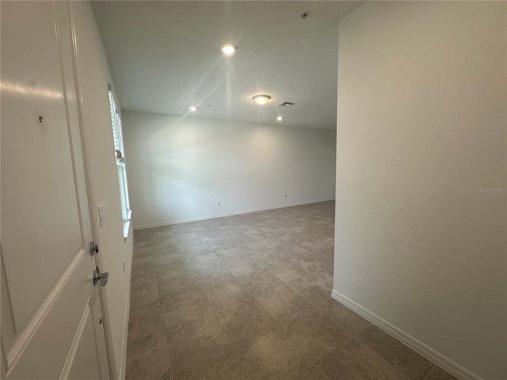 A view from a doorway into an empty room with light-colored tile flooring — 4620 ORCHARD VIEW ALLEY, CLERMONT, FL