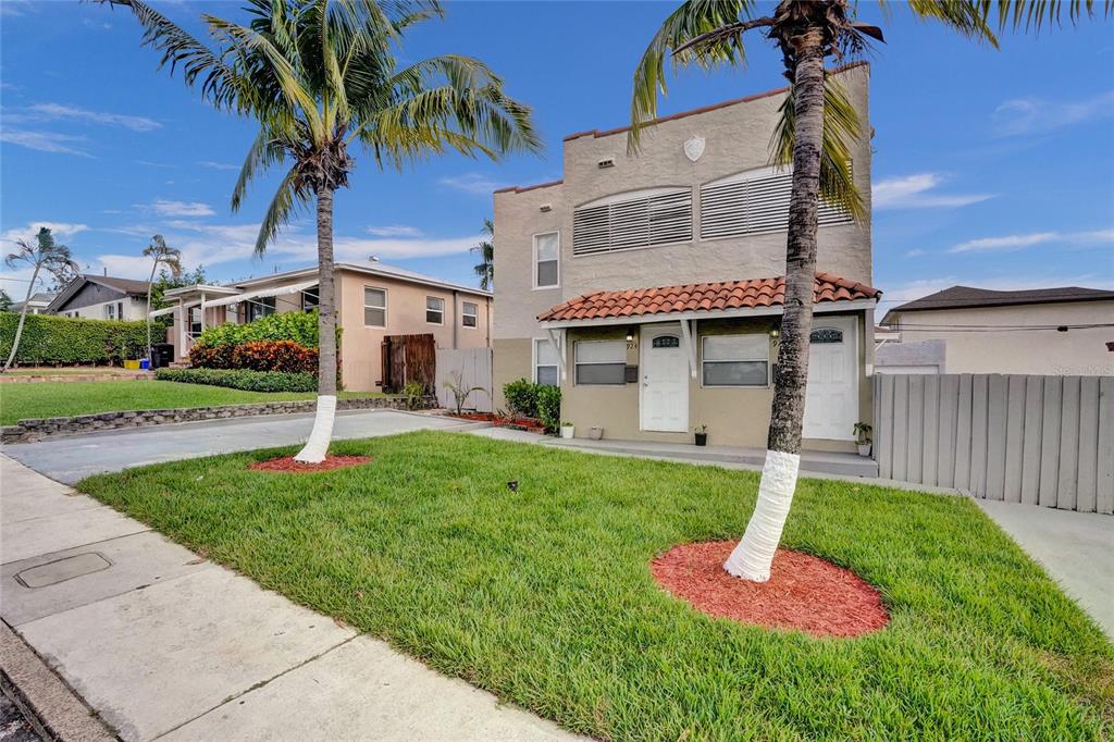 A two-story stucco duplex with a tiled entryway and two palm trees in the front yard — 924 MCINTOSH STREET, WEST PALM BEACH, FL