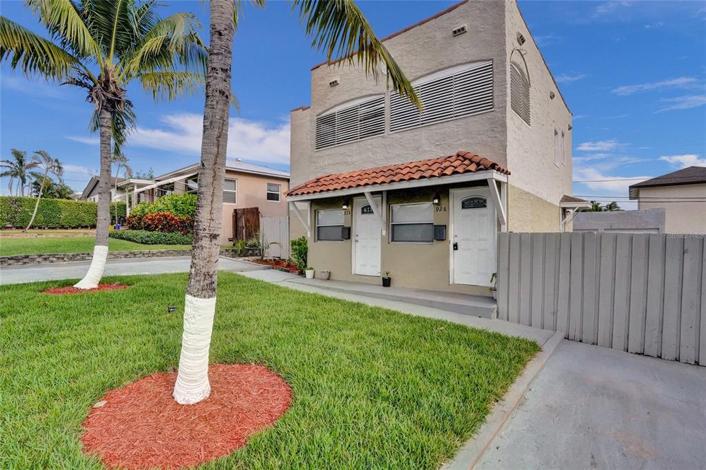 A two-story stucco building with a tiled awning over two front doors and palm trees — 924 MCINTOSH STREET, WEST PALM BEACH, FL