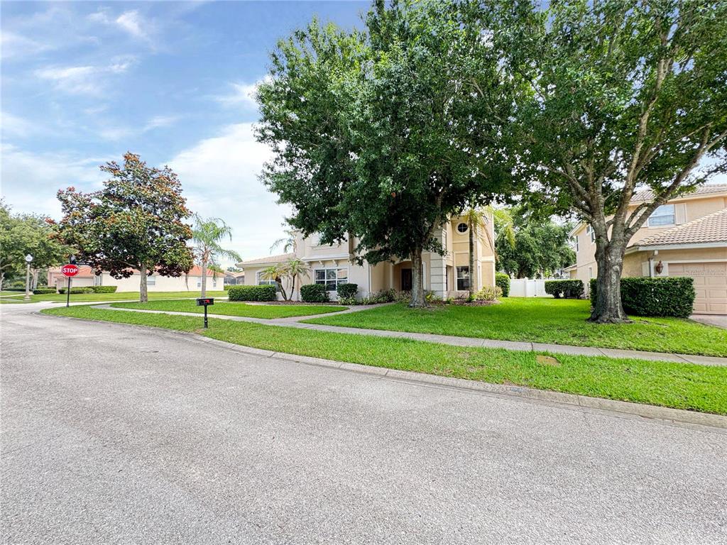 A two-story house with a large front yard and mature trees sits on a corner — 173 CALLIOPE STREET, OCOEE, FL