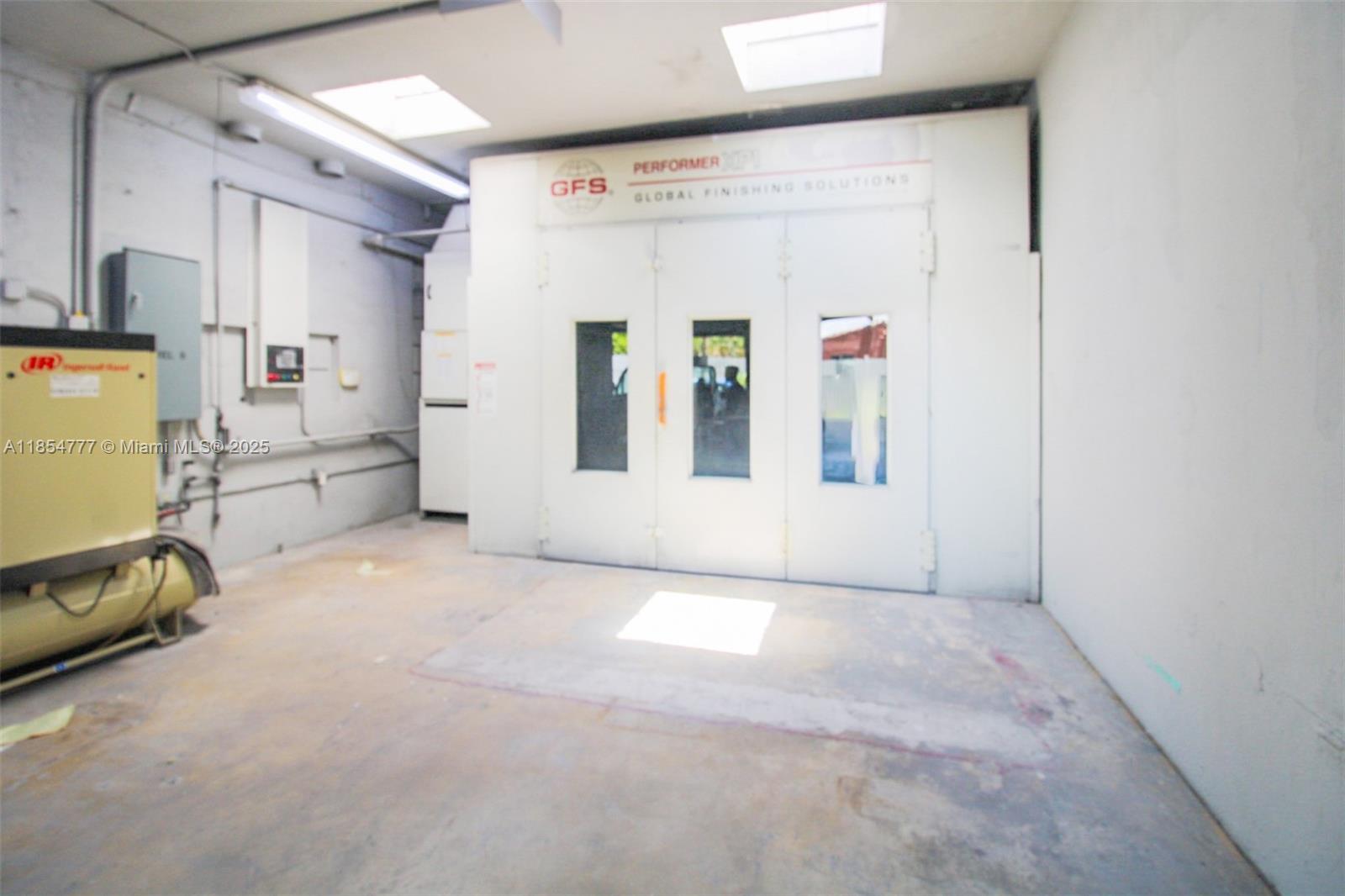 An industrial workspace features a large white GFS paint booth and an air compressor — 500 S Dixie Hwy, Hollywood FL 33020, HOLLYWOOD, FL