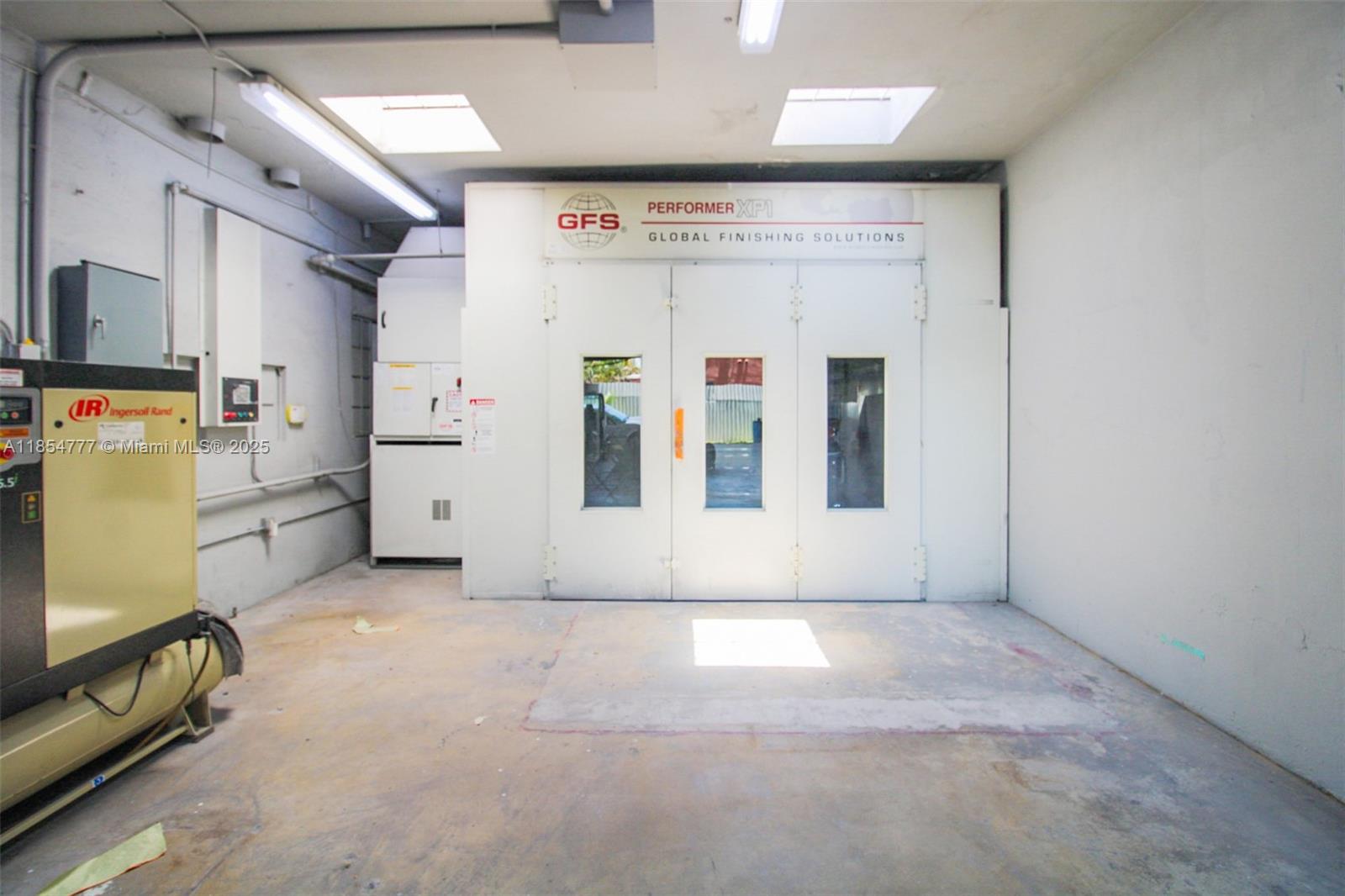 This industrial room features a large Global Finishing Solutions paint booth and an air compressor — 500 S Dixie Hwy, Hollywood FL 33020, HOLLYWOOD, FL