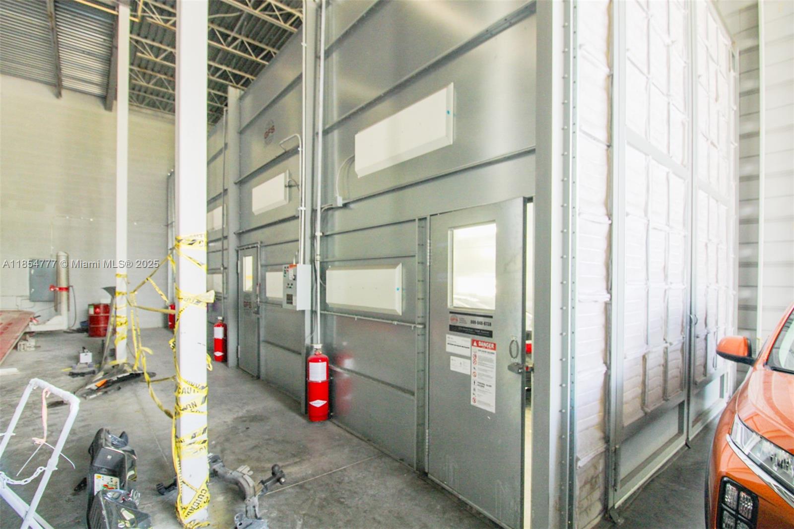 A warehouse interior features two industrial paint spray booths with metal walls and fire extinguishers — 500 S Dixie Hwy, Hollywood FL 33020, HOLLYWOOD, FL