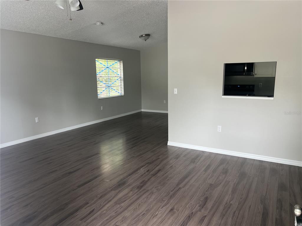 An interior view of a living room with gray walls and dark wood-look flooring — 2542 22ND STREET, SARASOTA, FL