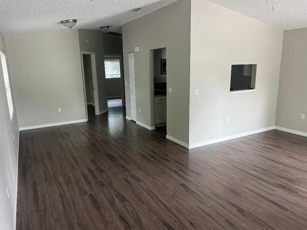 An interior view of a living area with wood-look flooring and a wall cutout — 2542 22ND STREET, SARASOTA, FL