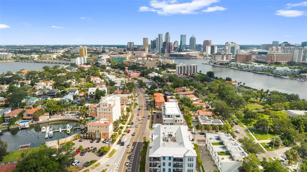 An aerial view shows a city skyline across a river with residential buildings and streets — 905 VILLA VENICIA WAY, TAMPA, FL
