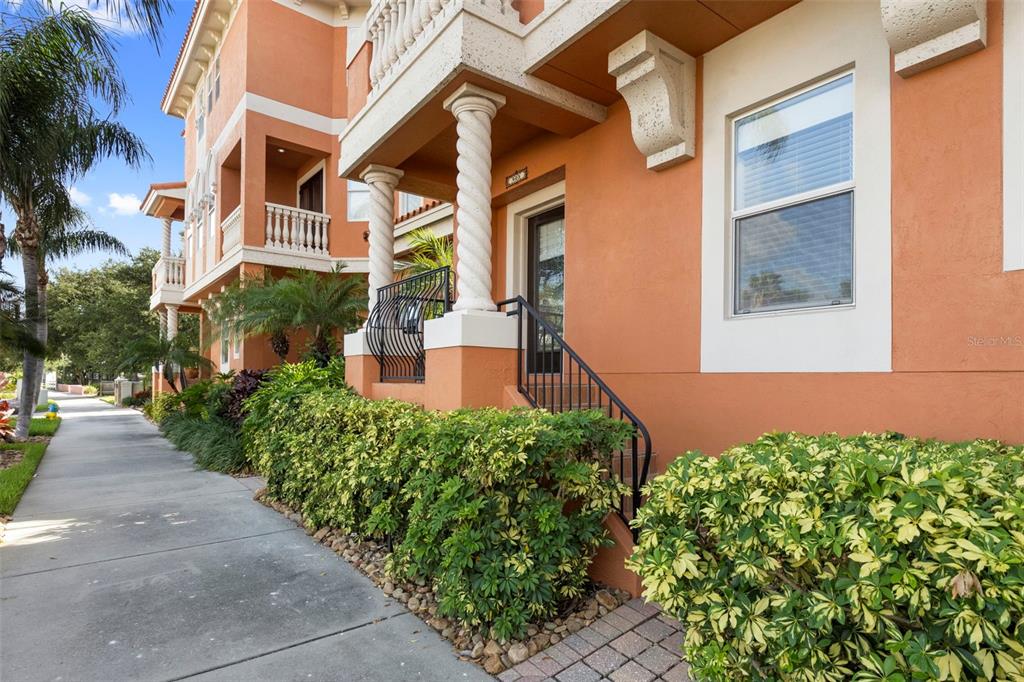 An orange multi-story building features a spiral column, a small porch, and a sidewalk — 905 VILLA VENICIA WAY, TAMPA, FL
