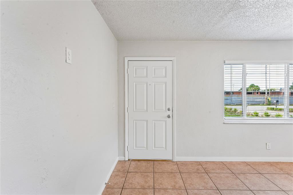 An interior room features a white door, a window with blinds, and tiled flooring — 6229 50TH AVENUE N, ST PETERSBURG, FL