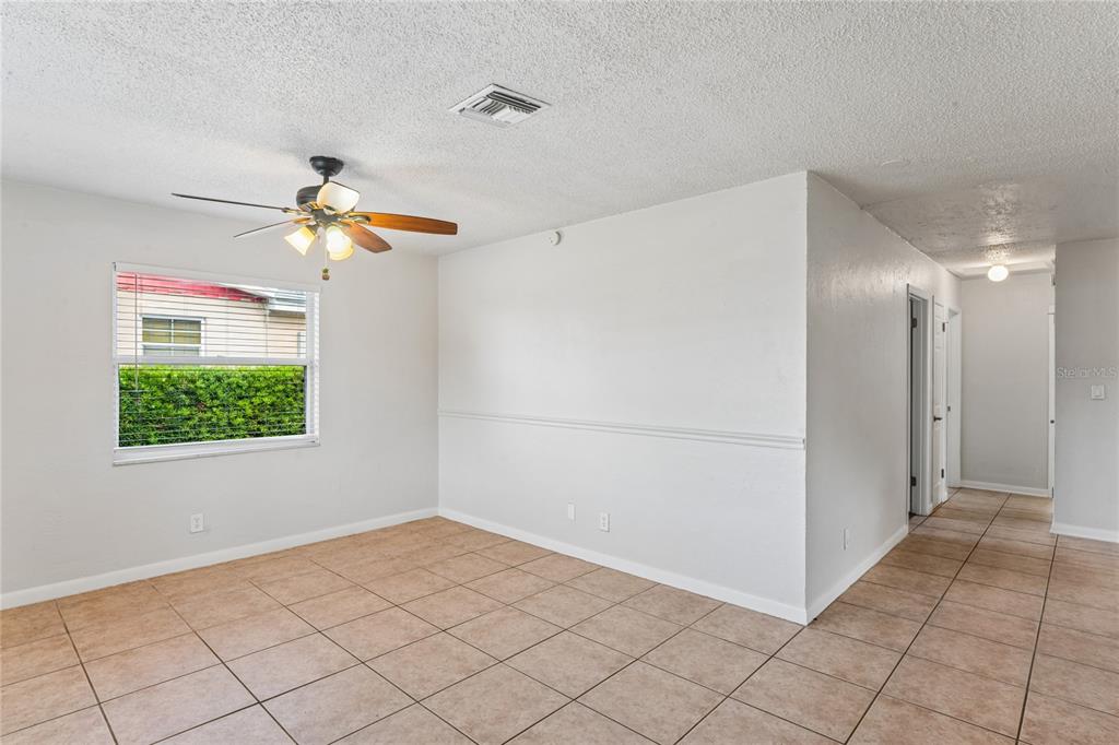 A room with beige tile flooring, white walls, a ceiling fan, and a window — 6229 50TH AVENUE N, ST PETERSBURG, FL