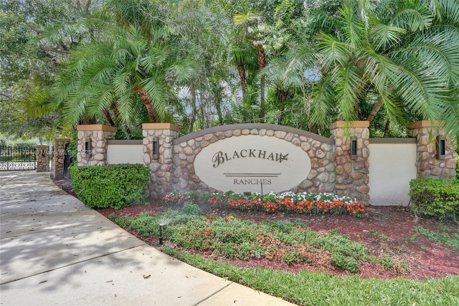 A stone monument sign for Blackhawk Ranches stands behind a landscaped garden with palm trees — 11056 Blackhawk Blvd, Davie FL 33328, DAVIE, FL