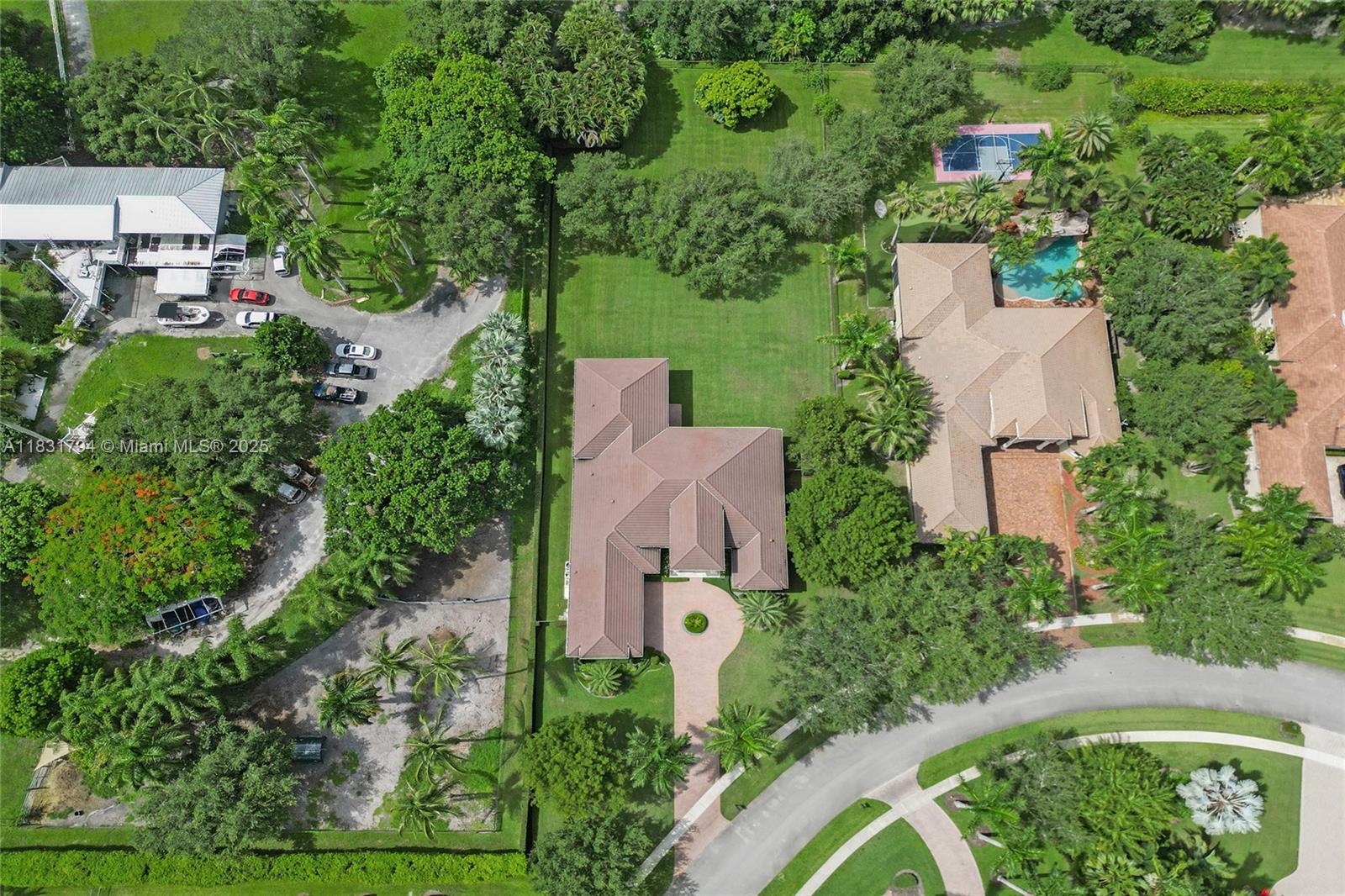 An aerial view shows a residential property with a large house, pool, and landscaped grounds — 11056 Blackhawk Blvd, Davie FL 33328, DAVIE, FL