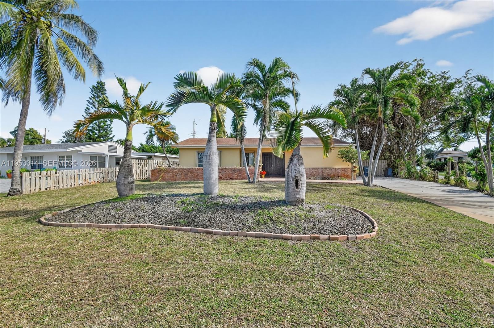 A single-story house with a gravel landscaping bed and several palm trees in the front yard — 1712 High Ridge Rd, Lake Worth FL 33461, LAKE WORTH, FL