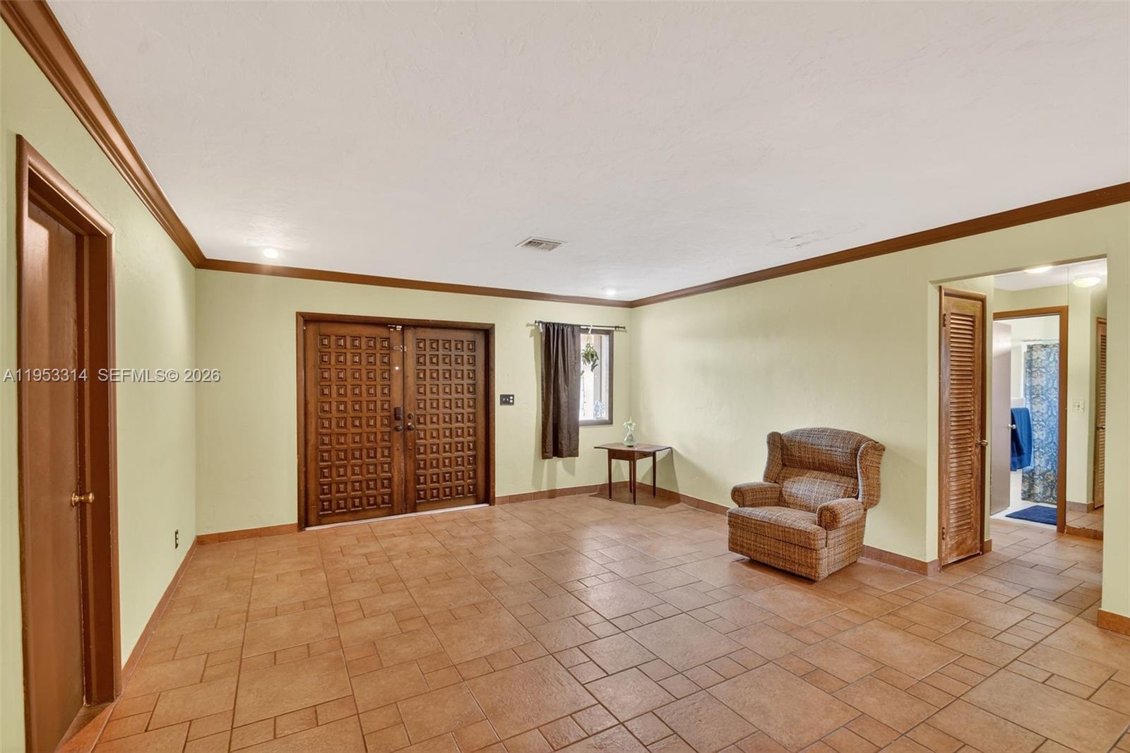 An entryway features a patterned double door, tile flooring, and a single armchair — 1712 High Ridge Rd, Lake Worth FL 33461, LAKE WORTH, FL