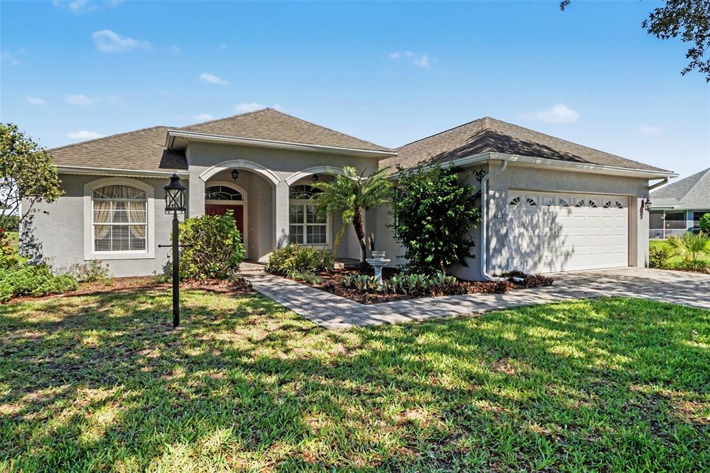 A single-story house with a gray stucco exterior, a two-car garage, and a paved walkway — 4287 N COURSE LANE, AVON PARK, FL