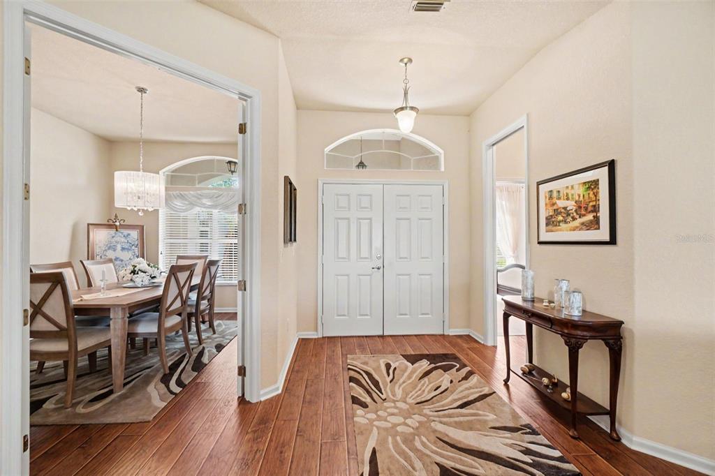 A foyer with wood floors, a patterned rug, and a double front door — 4287 N COURSE LANE, AVON PARK, FL