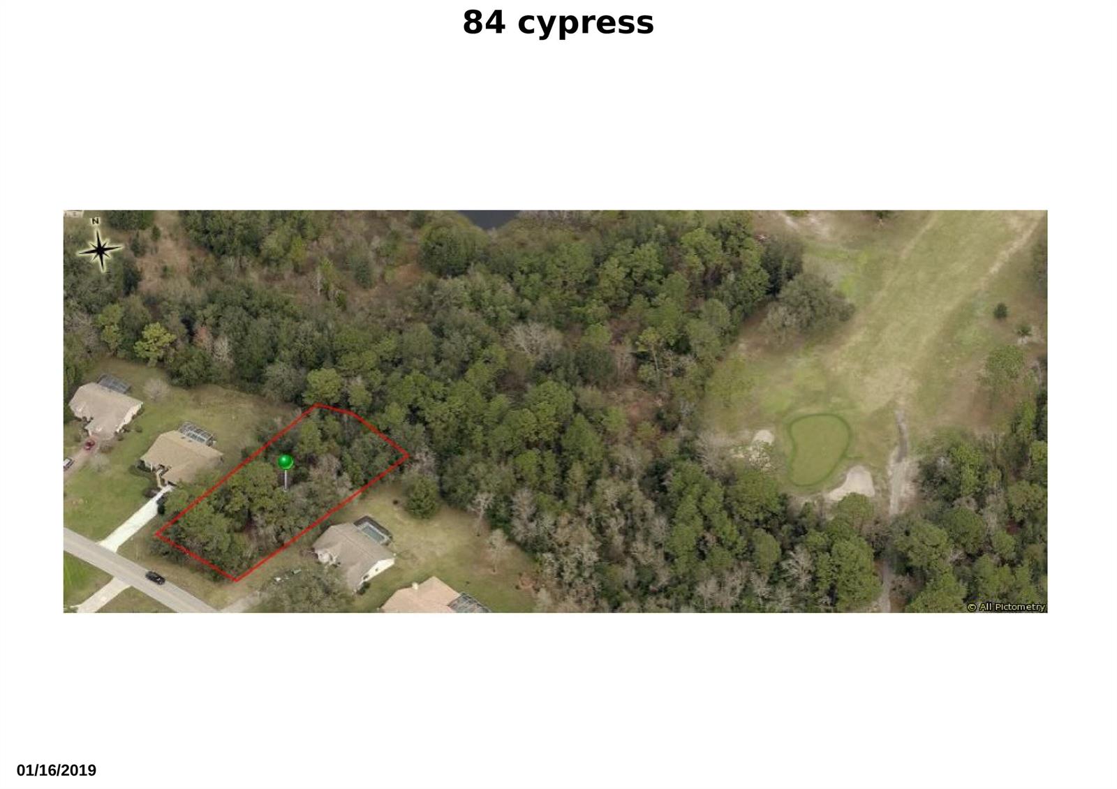 This aerial view shows a wooded residential lot outlined in red next to a golf course — 84 Cypress Boulevard W, FL 34446, FL
