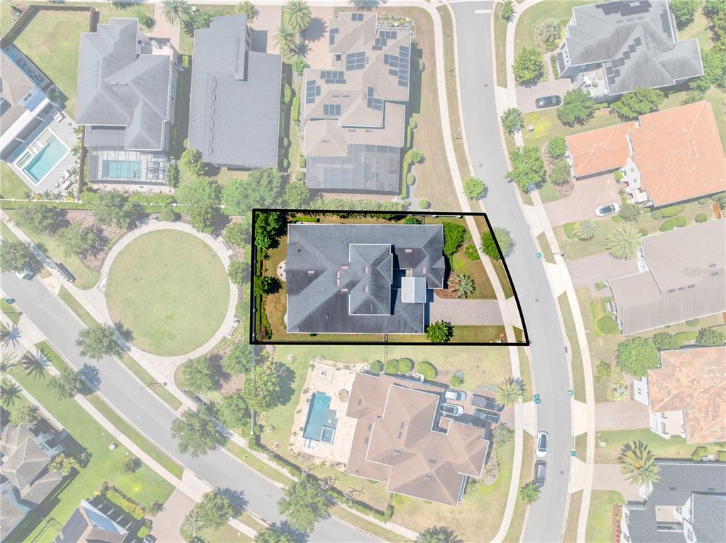 An aerial view shows a residential house with a dark roof on a corner lot — 12735 BANTING TERRACE, ORLANDO, FL