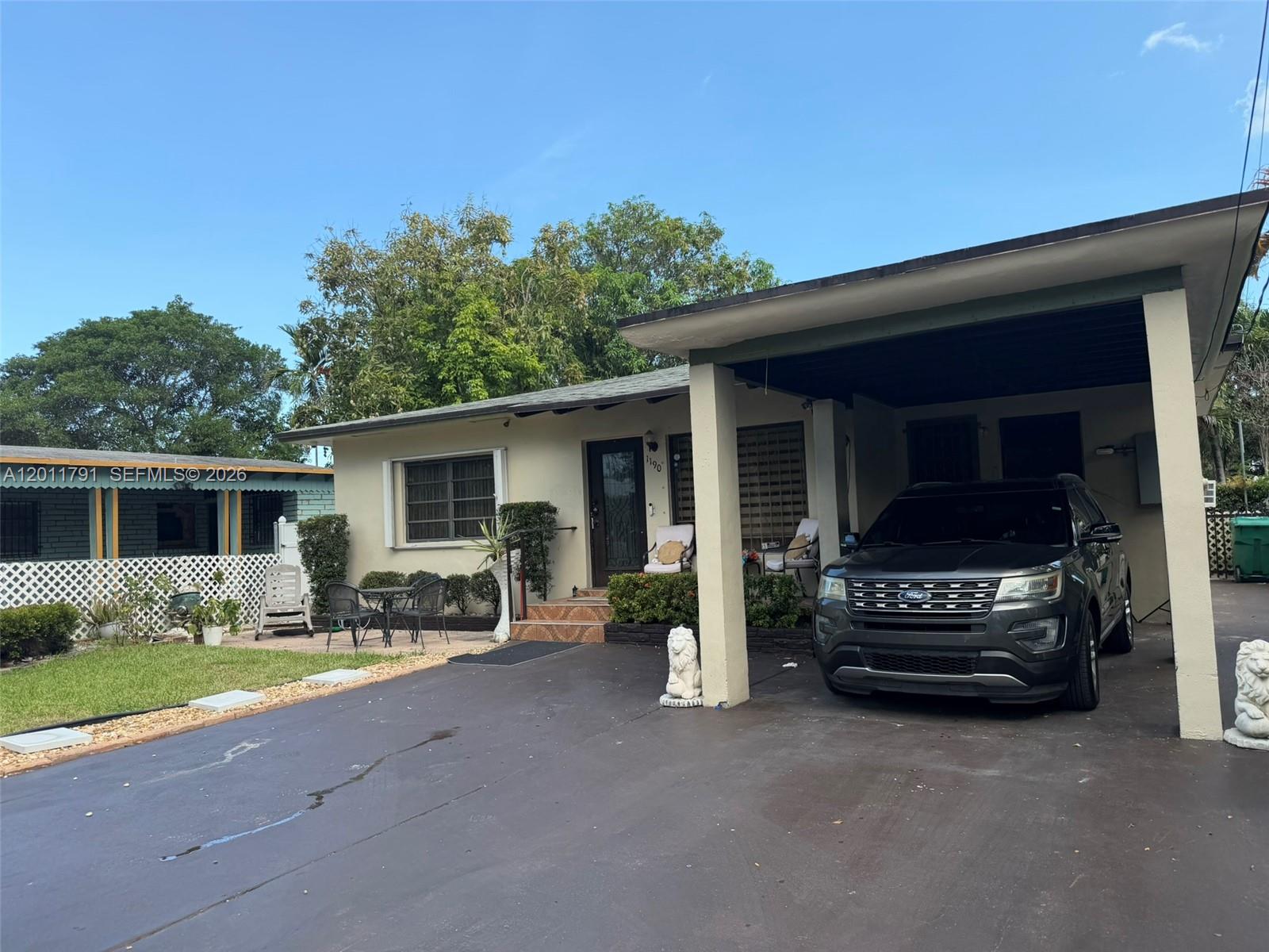 A single-story house with a carport, a paved driveway, and a small front patio area — 1190 NW 50th St, Miami FL 33127, MIAMI, FL