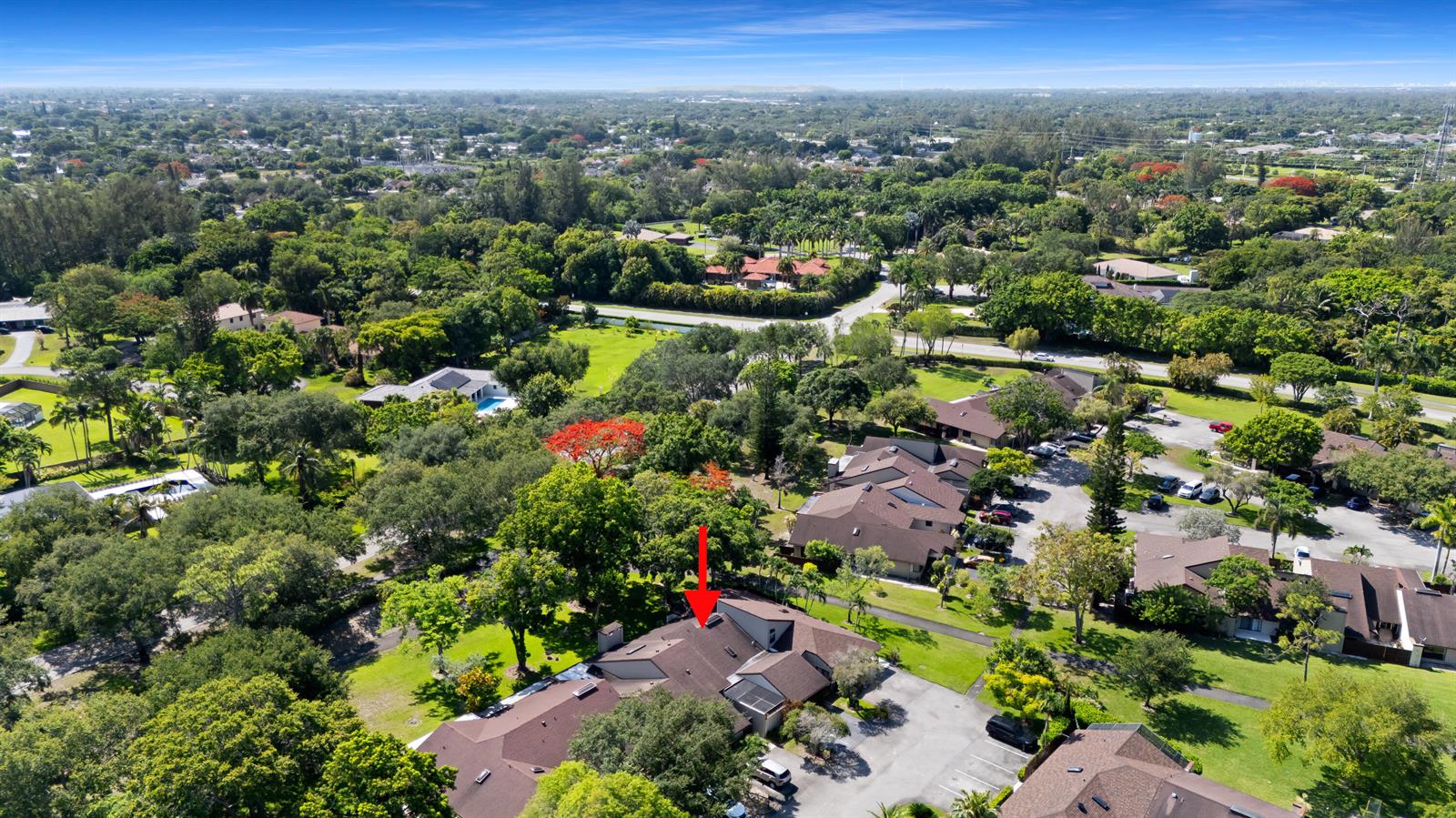An aerial view shows a residential complex with brown roofs surrounded by lush green trees — 22656 Vistawood Way # 29d, Boca Raton FL 33428, BOCA RATON, FL