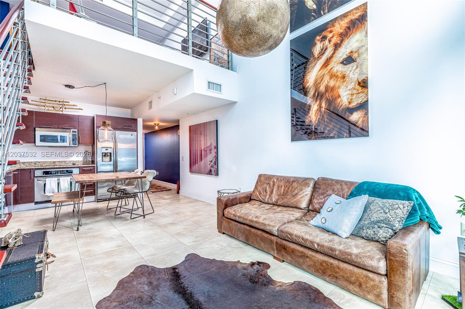 A living room with a leather sofa, cowhide rug, and a large lion wall art piece — 41 SE 5th St # 706, Miami FL 33131, MIAMI, FL